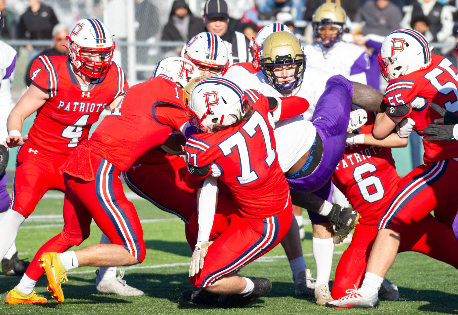 Ben Blythe (No. 77) and others gang tackle the Saints’ big running back Moses Mues in the fourth quarter.