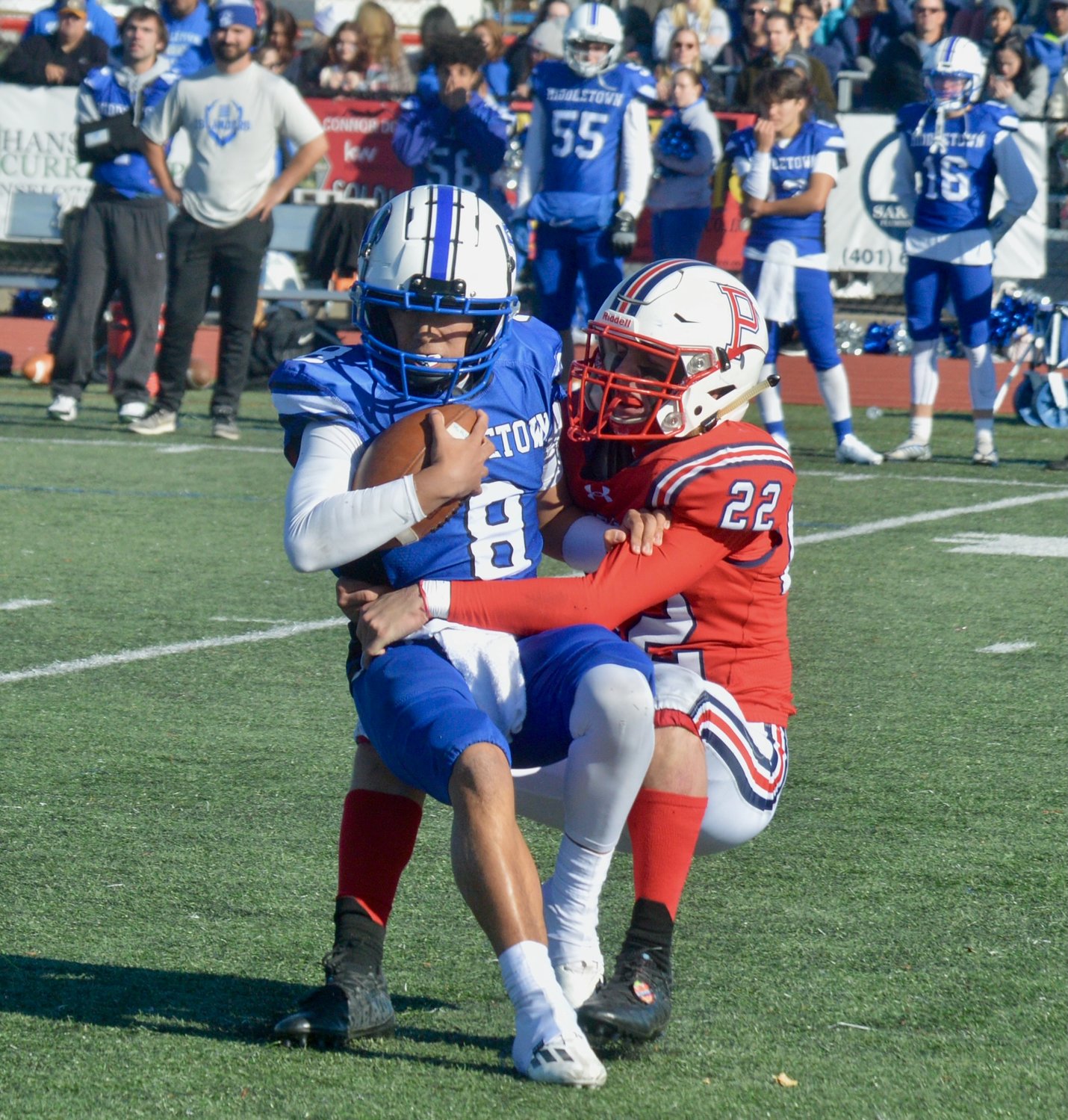 Middletown High quarterback Julien de la Cruz is muscled down by Portsmouth’s Dylan Brandariz for a big third-down loss in the second half, forcing the Islanders to punt.
