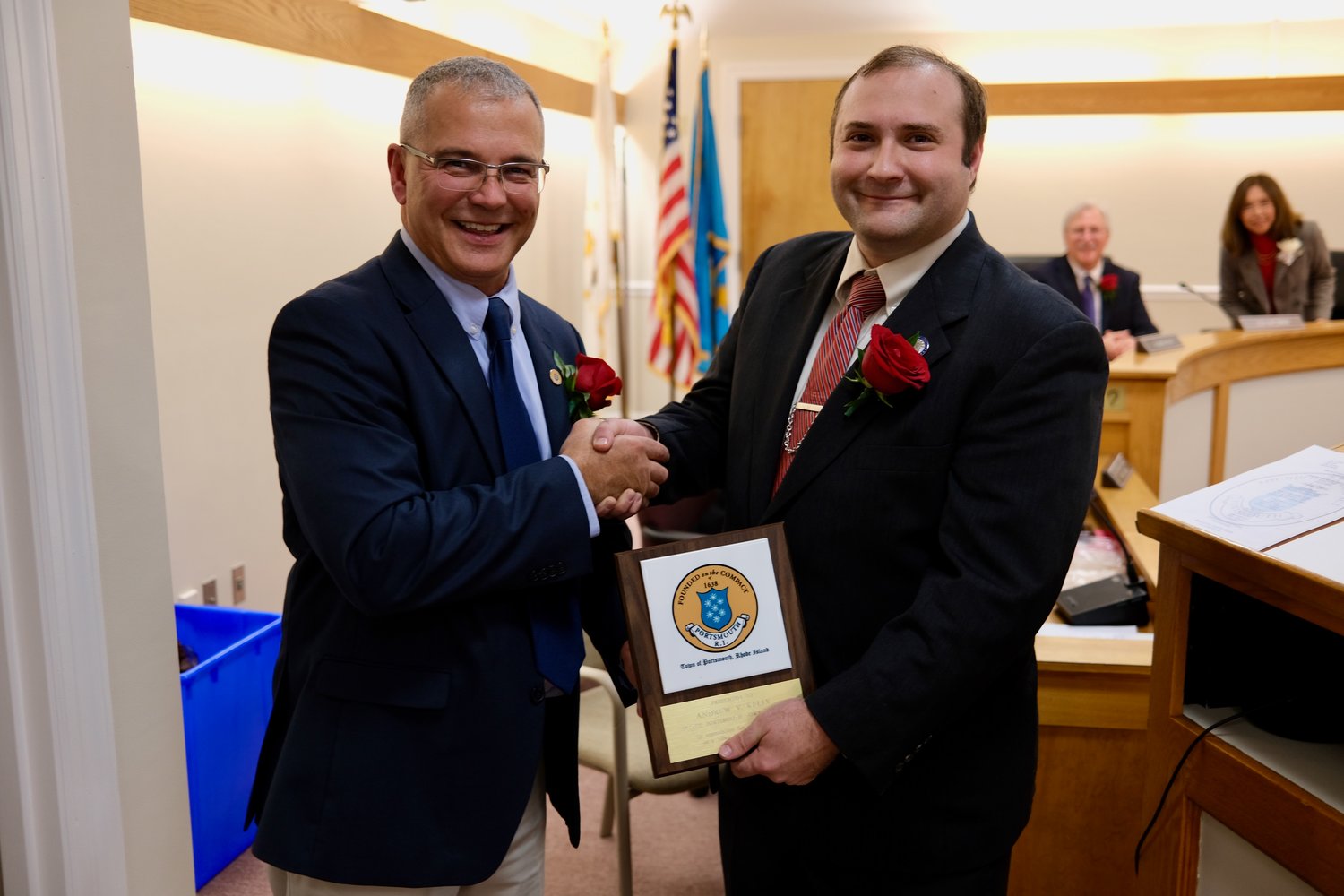 Town Council President Kevin Aguiar (left) presents a town tile to outgoing member Andrew Kelly.