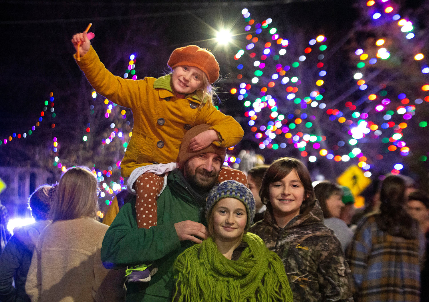 Nick Marcoux, Lynora, 7, (top), Djuna, 11, (middle) and Ari Machado, 13, (right) celebrate with the lights on Main Street. 