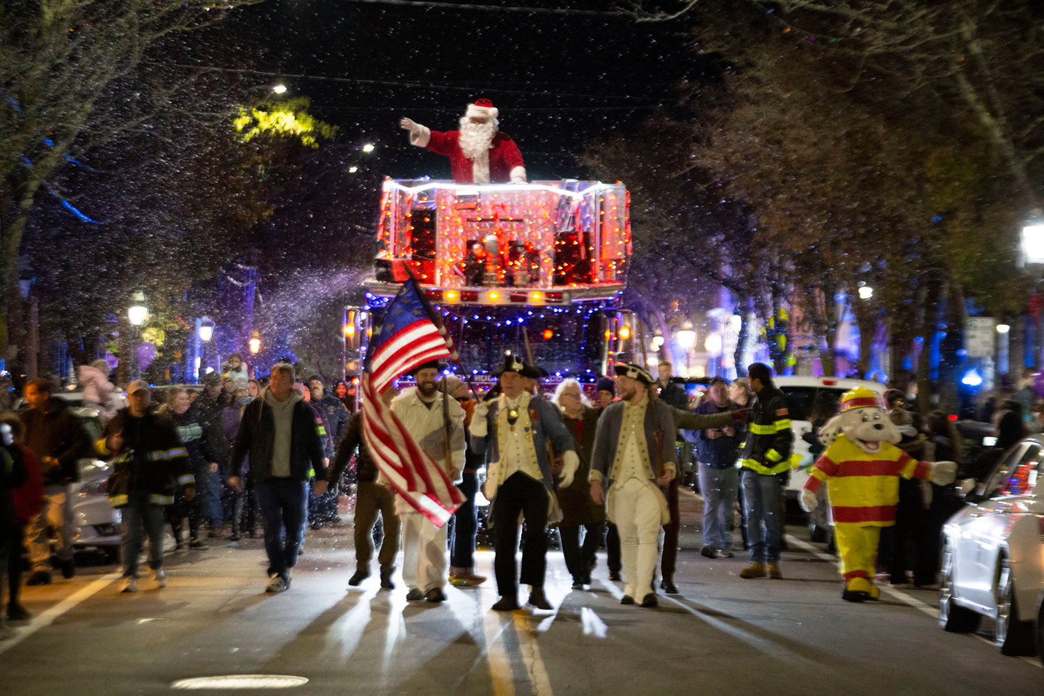 Santa Claus rides on top of Ladder One down Main Street during the Warren Holiday Festival parade, led by the Warren Federal Blues, town council and members of the general assembly.