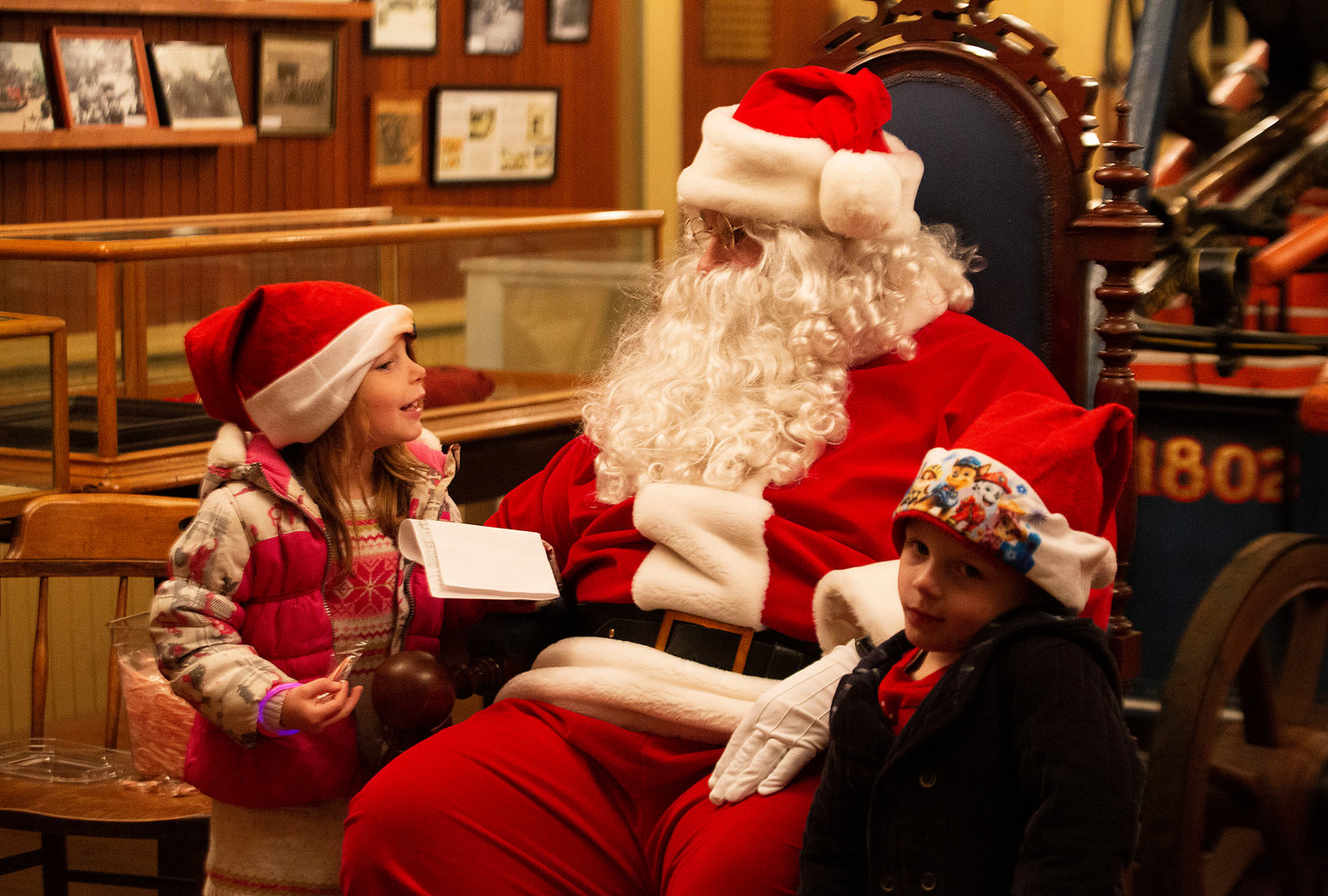 Ivy Sullivan, 5, and brother, Liam, 4, chat with Santa Claus inside the Warren Fireman’s Museum. 