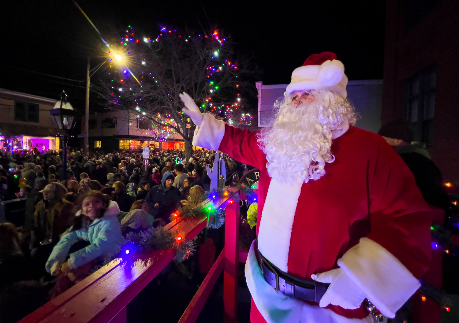 Santa waves to the throng after turning on the Christmas lights on Main Street. 