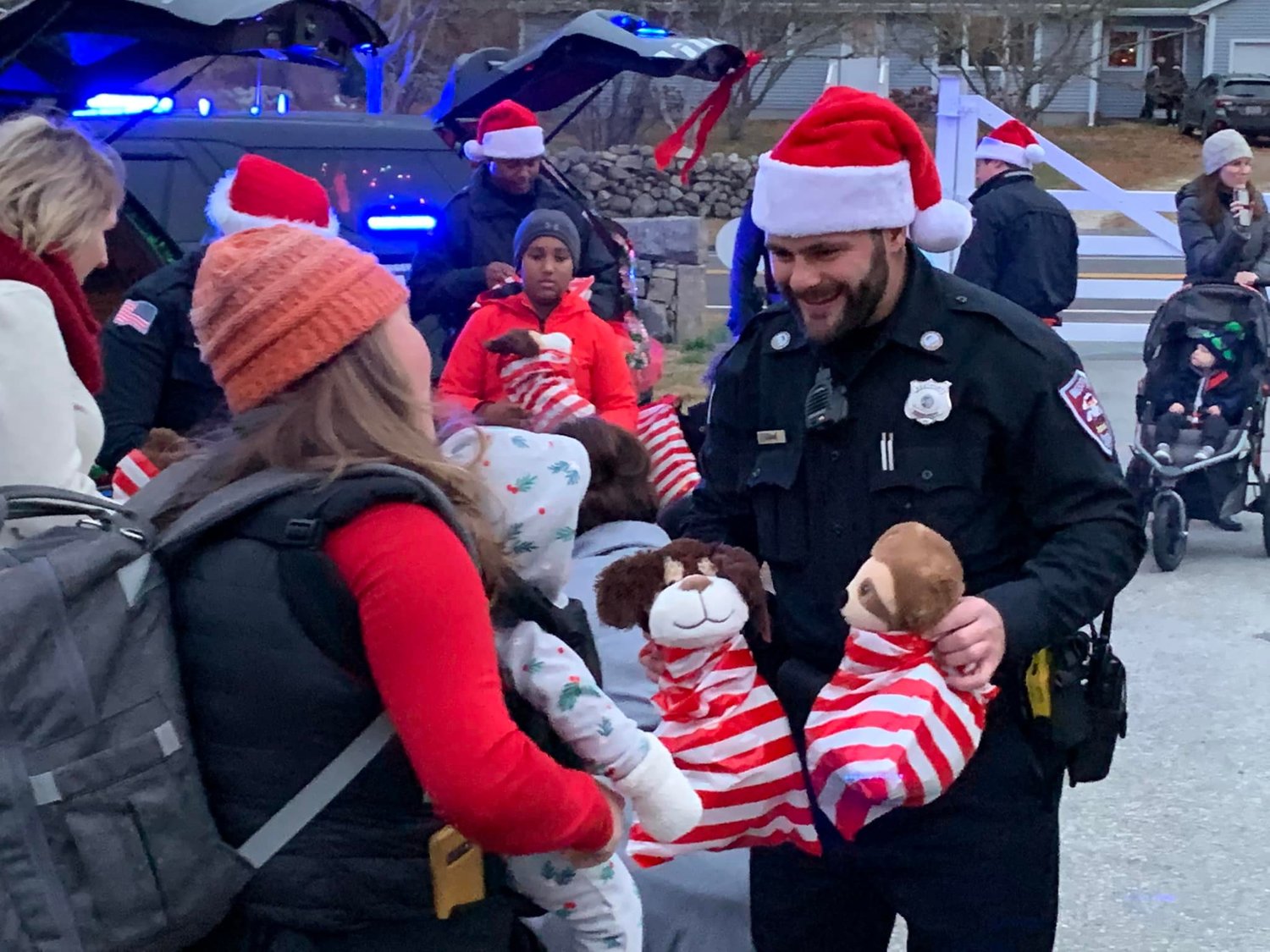 A Westport police officers shares toys with a young friend at last year's lighting festival.