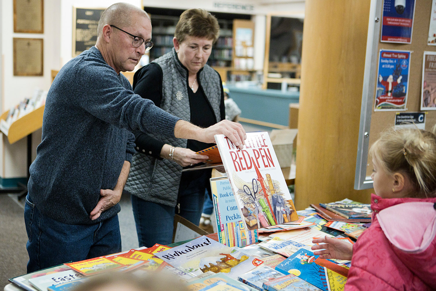 Dwayne and Patricia Peckham brought a tableful of books for children to take home for free in memory of their late son, Connor. Connor, a popular student and band member at Portsmouth High School who organized a book giveaway during the library’s 2018 tree-lighting for his senior project, died the following year at the age of 18.