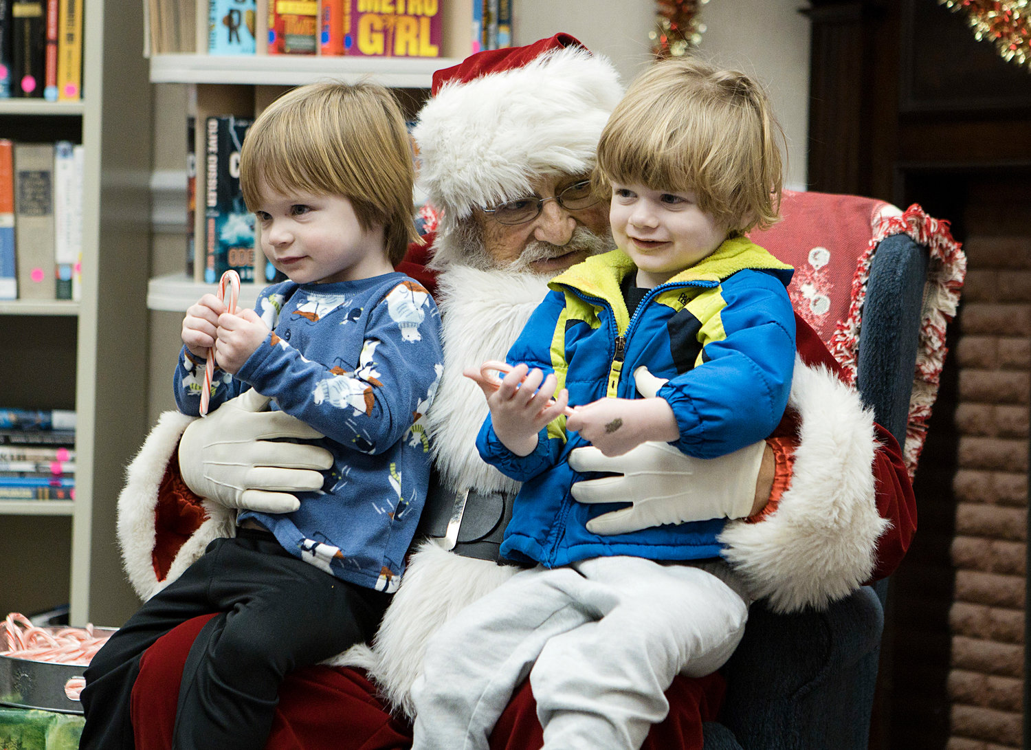 Val (left) and Desi Nicholas sit on Santa’s lap clutching candy canes.