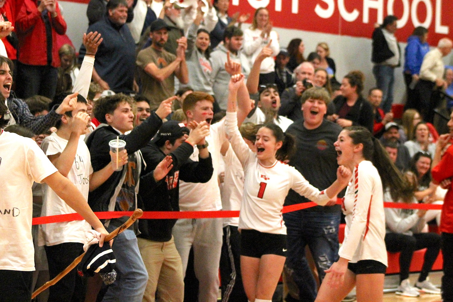 East Providence High School girls’ volleyball players Brookelyn Feola and Keira Mullen (right) celebrate with members of “The Herd” after their victory in the Division II championship playoff semifinals earlier this fall.