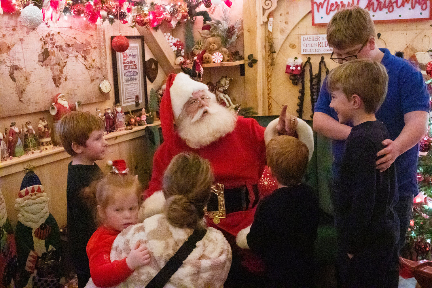 Noah Gill, 4, (left), Penny Gill, 2, with mom, Brady Gill, 6, Aidan Gill, 8, and William Gill, 12, chat with Santa inside the Santa House.