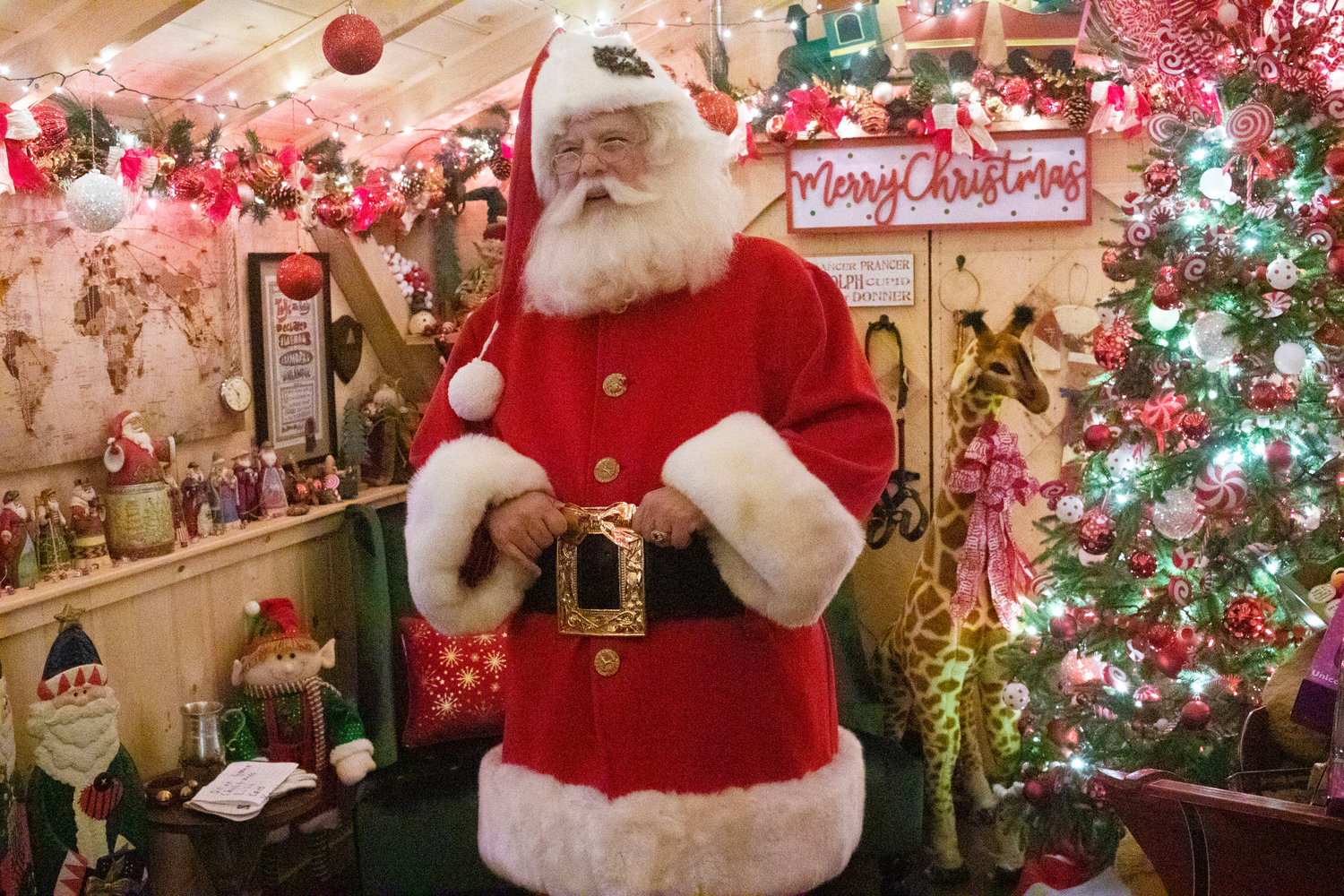 Santa Claus prepares to welcome guests to his house during last year’s inaugural opening. The house has a new location this year on the Town Common.