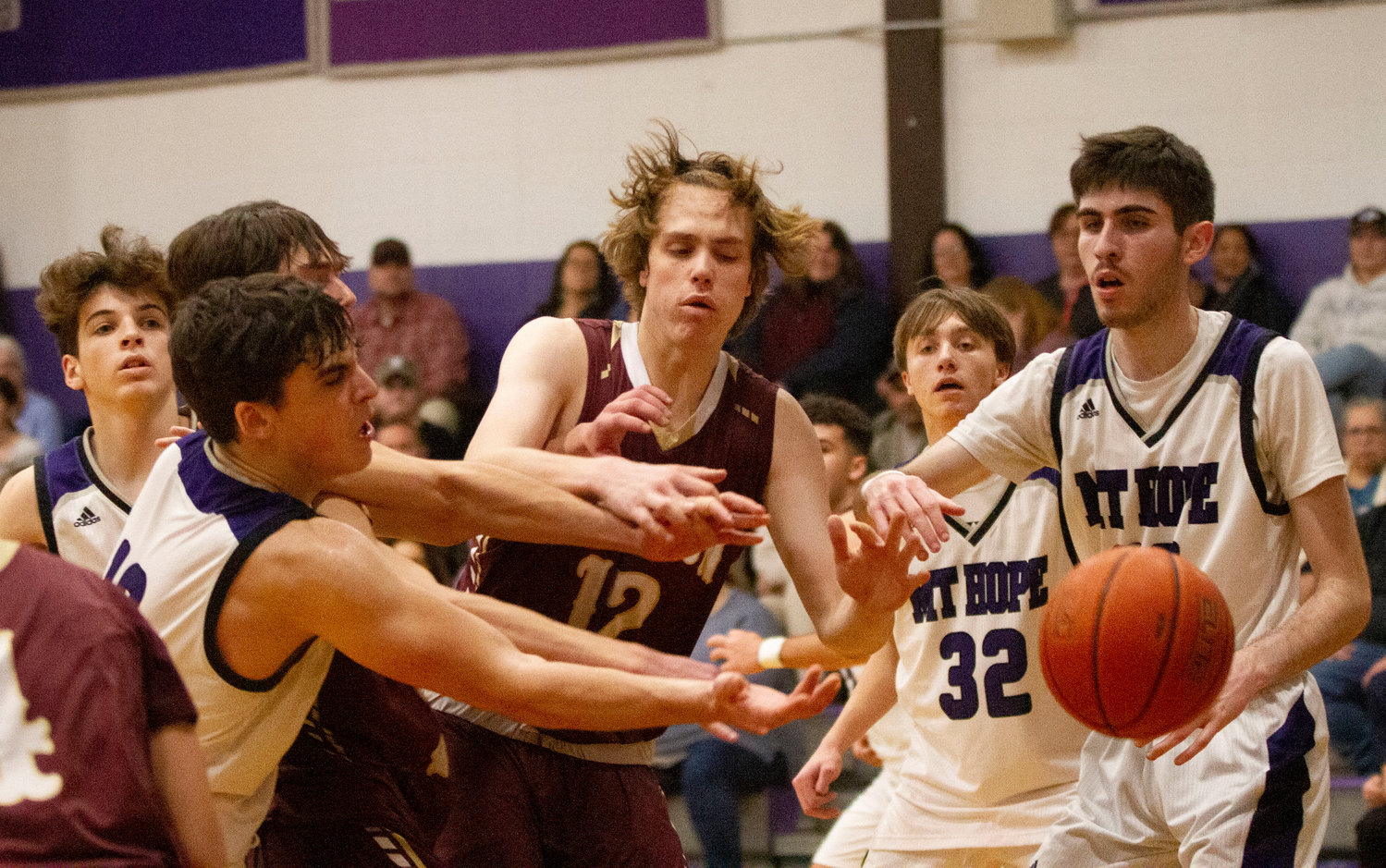 Ethan Santerre (left) and Lucas Andreozzi look on as Ben Calouro Jason Potvin and James Rustici vie for a rebound in a scrappy played game at Mt. Hope High School.