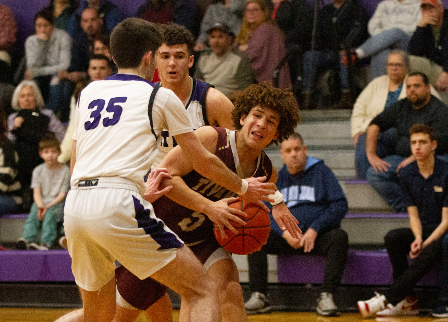 James Rustici (left) and Parker Camelo surround Tristin White as he tries to get to the hoop.