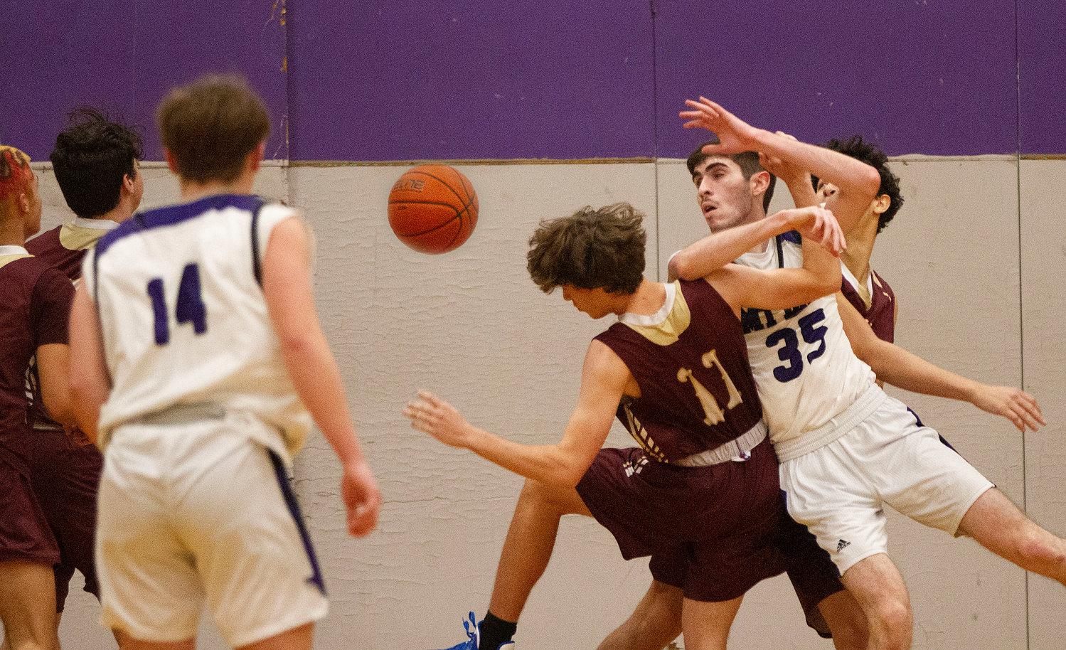 Mt. hope's James Rustici vies for a rebound with a pair of Tiverton players.