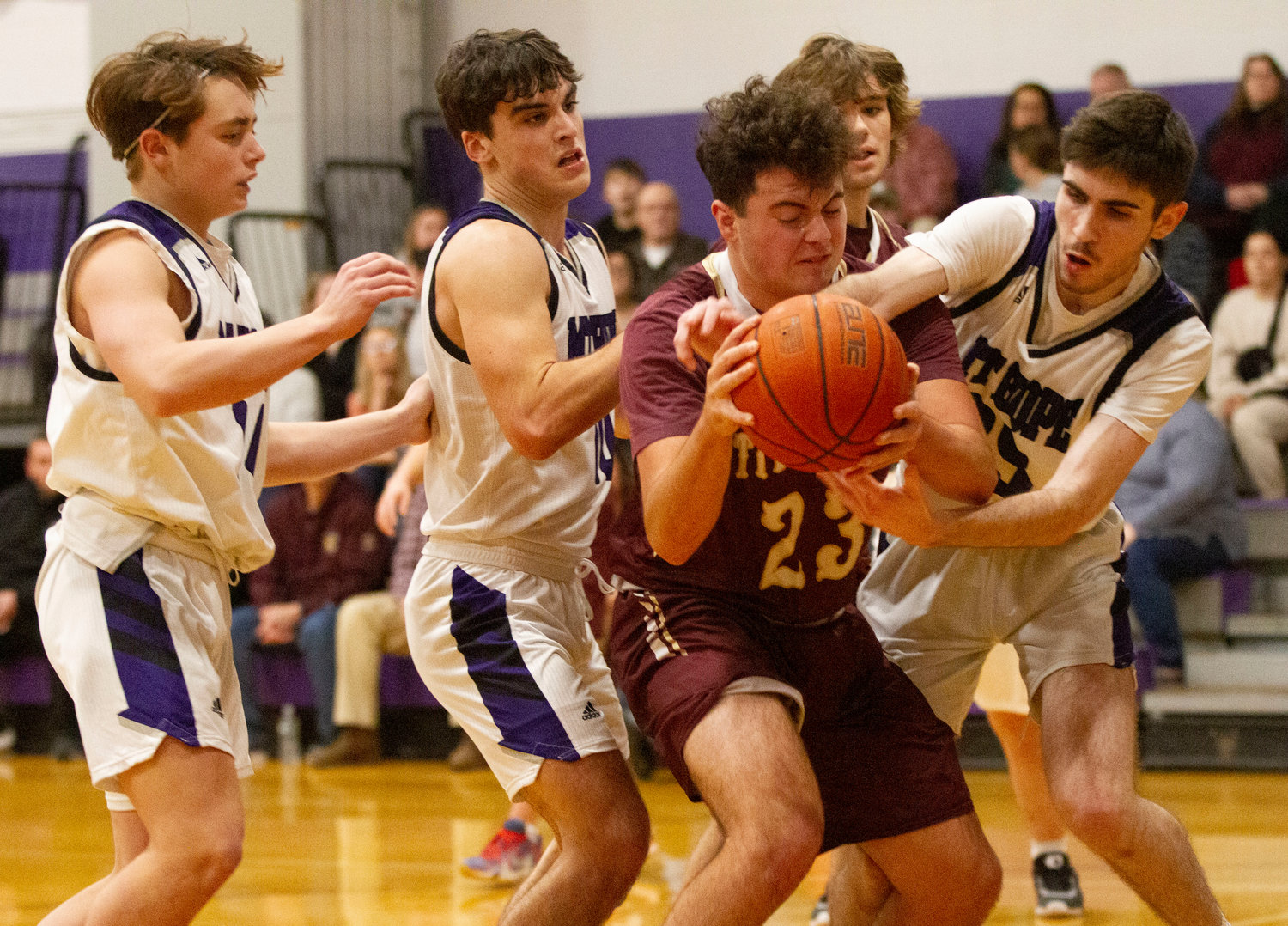 Huskies defenders Matt MacDougall, Ben Calouro and James Rustici fight for a rebound with Tiverton's Ryan Poland.
