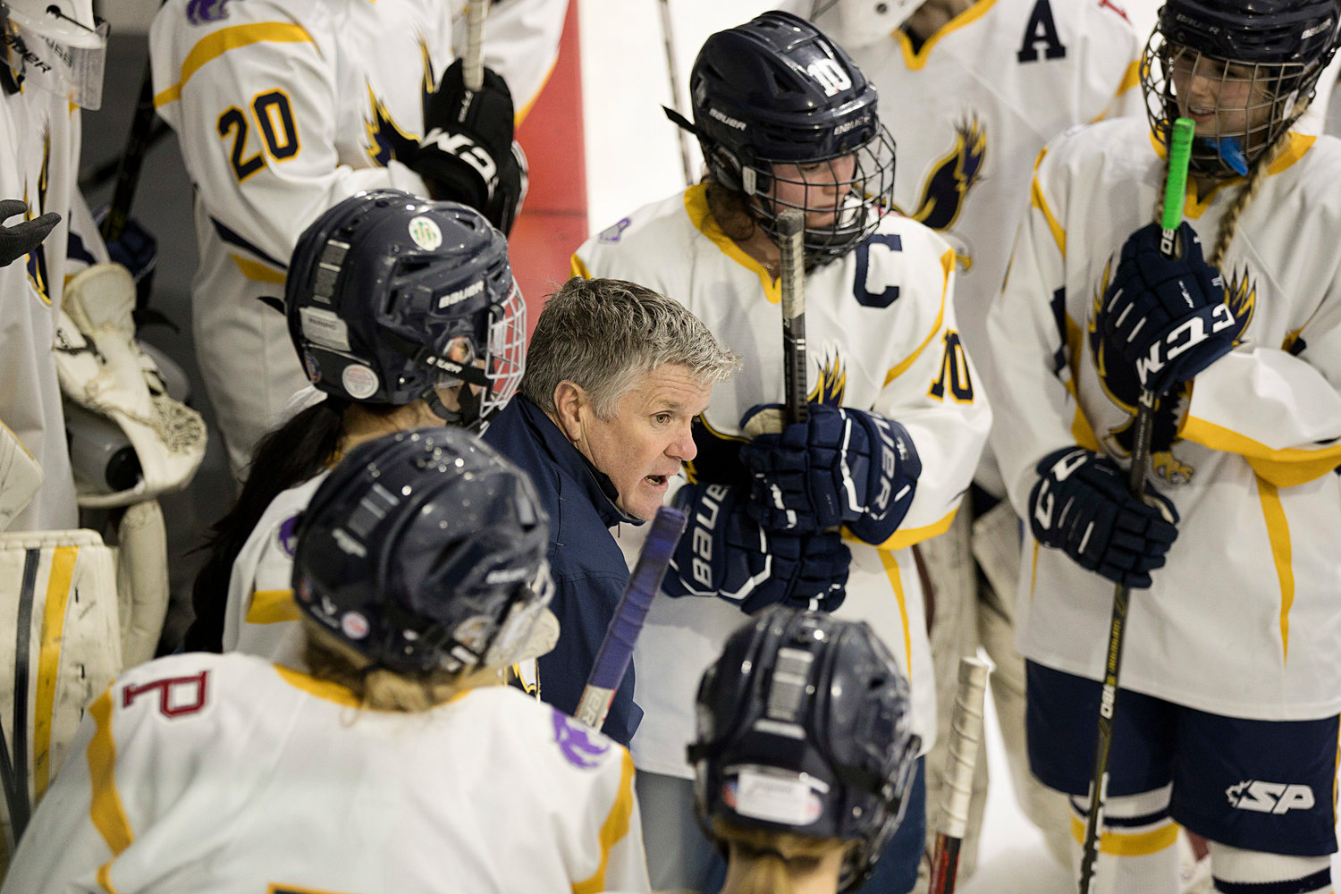 Michael Cox, head coach of the Barrington/Mt. Hope/Portsmouth girls’ co-op hockey team, talks with members of his squad during a timeout.