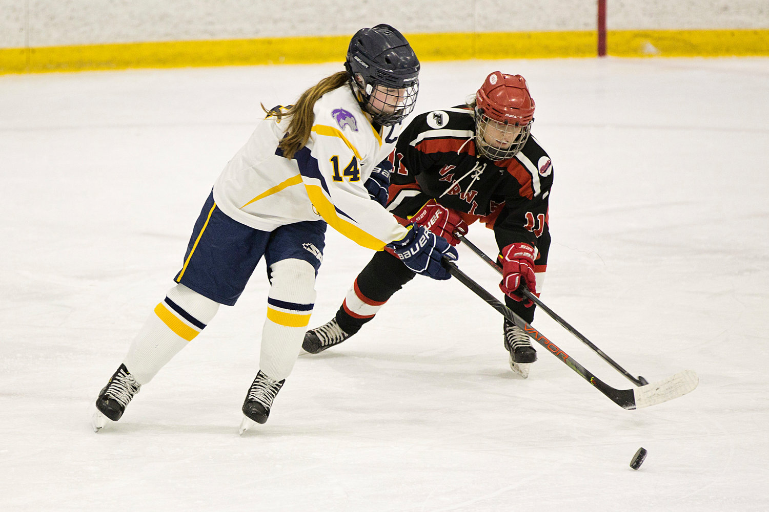 Barrington’s Peyton Whittet battles her opponent for possession of a loose puck.