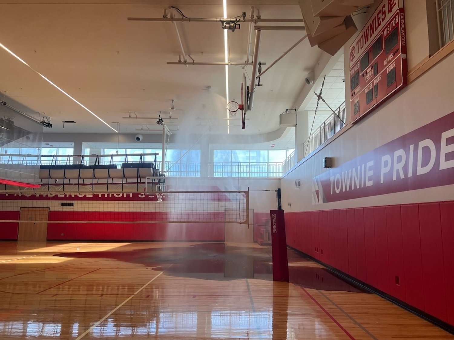 The sprinkler inside the EPHS gym is activated just after an errant strike by a student playing volleyball during a physical education class.