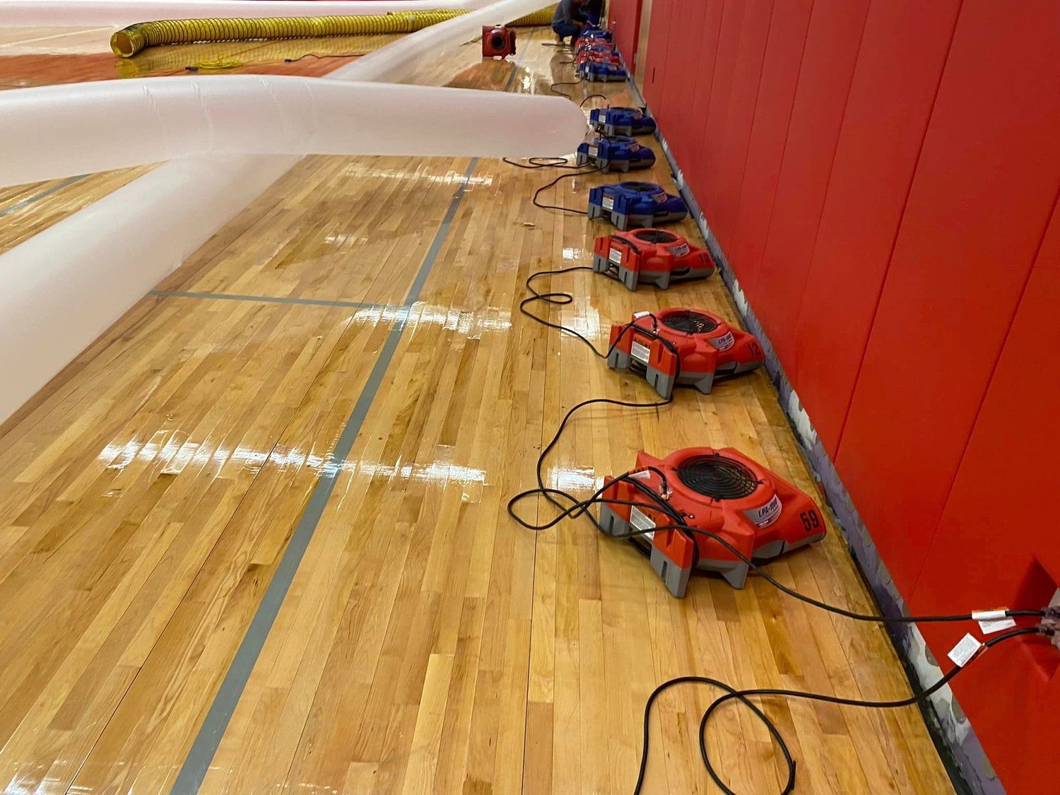 A view of the some of the fans used by Clean Care New England to assist in draw out water inside the EPHS gym following the accidental sprinkler discharge.