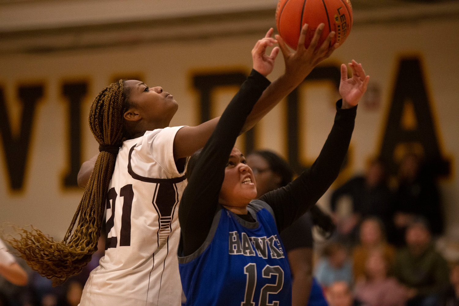 Jenna Egbe grabs a rebound away from a Southeastern player with one hand.