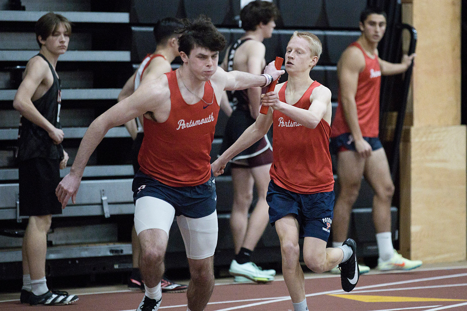 Nate DeConto hands the baton off to teammate Nick Spaner after running the first leg of the 4x200-meter relay, which the Patriots won in a season-best time of 1:37.52.