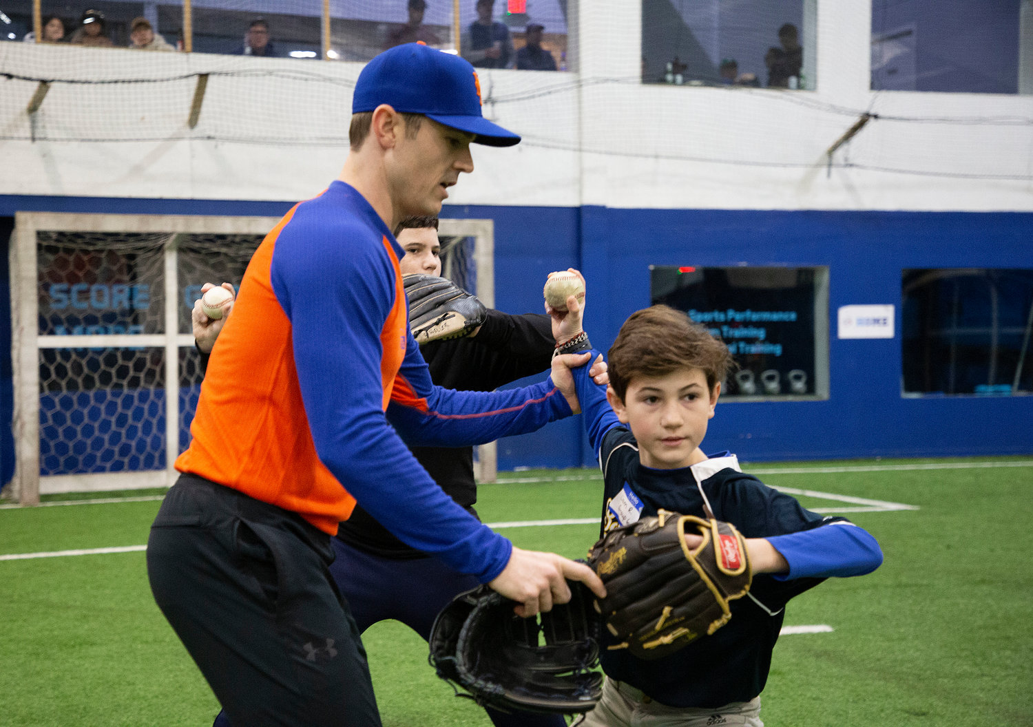 NY Mets pitcher David Robertson helps Liam Reardon with his throwing technique during a special skills clinic last weekend.