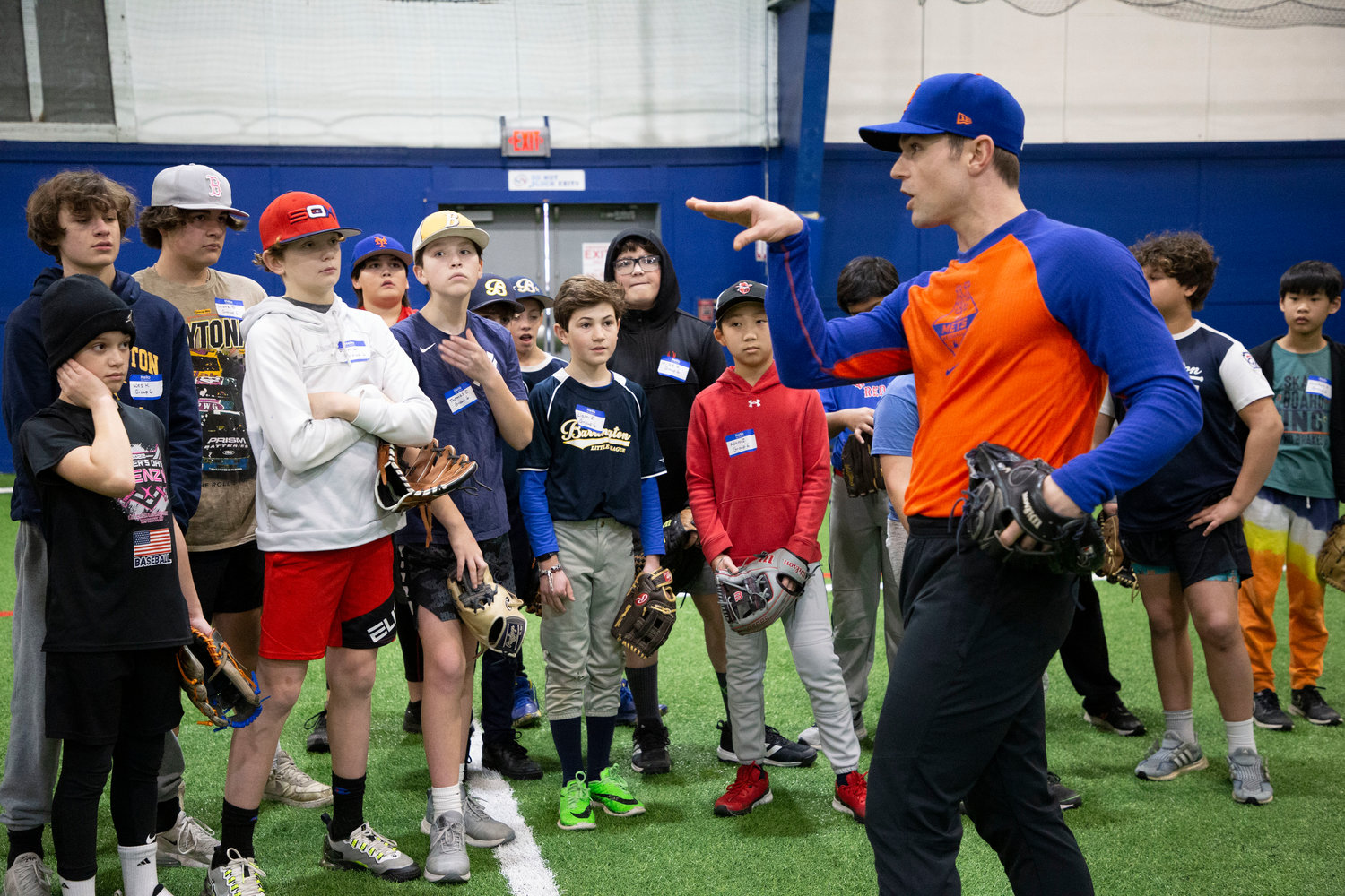 NY Mets pitcher David Robertson speaks to a group of baseball players about proper throwing stance.