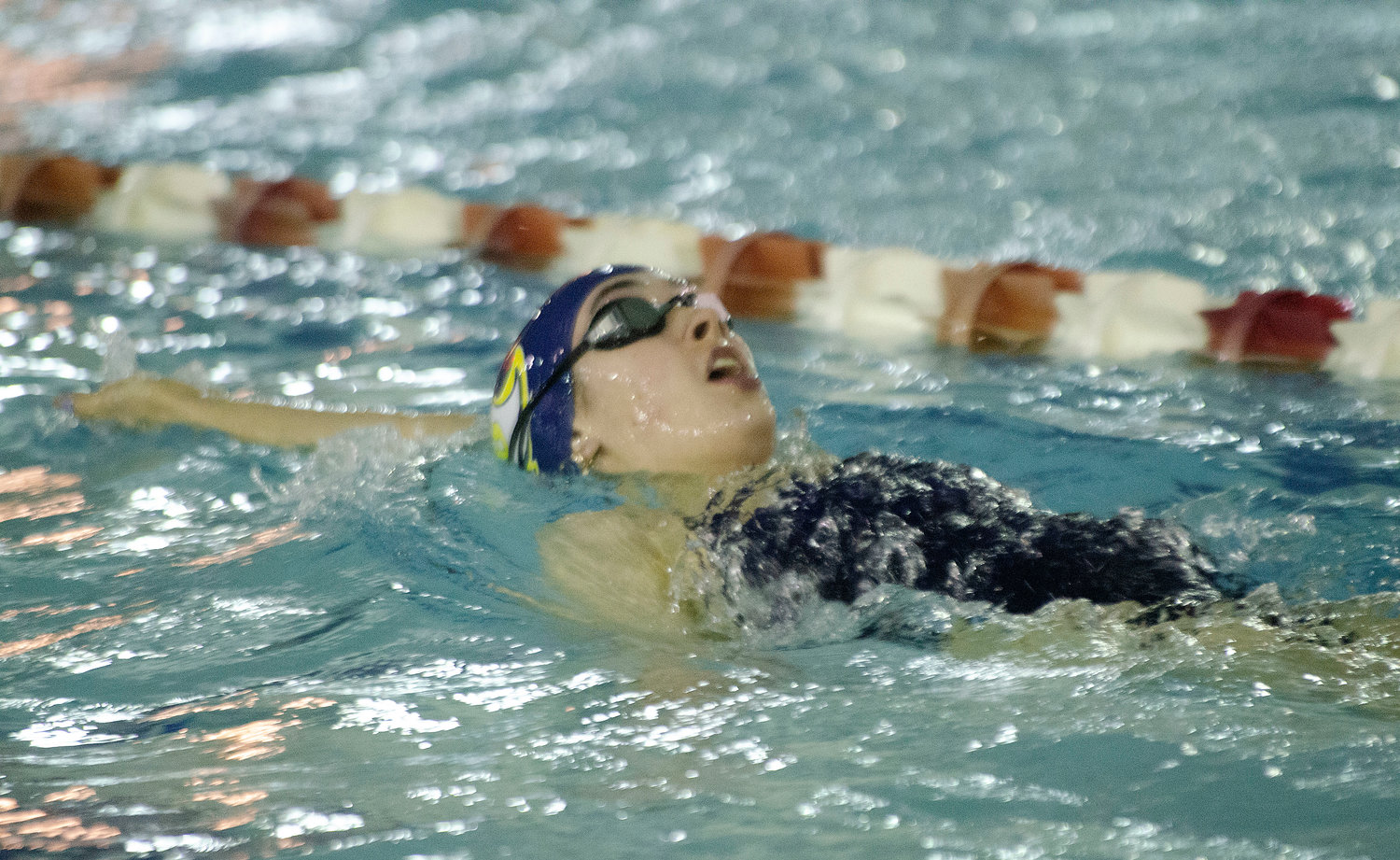 Barrington's Kristen Baker swims the backstroke during the Eagles' meet against Lincoln.
