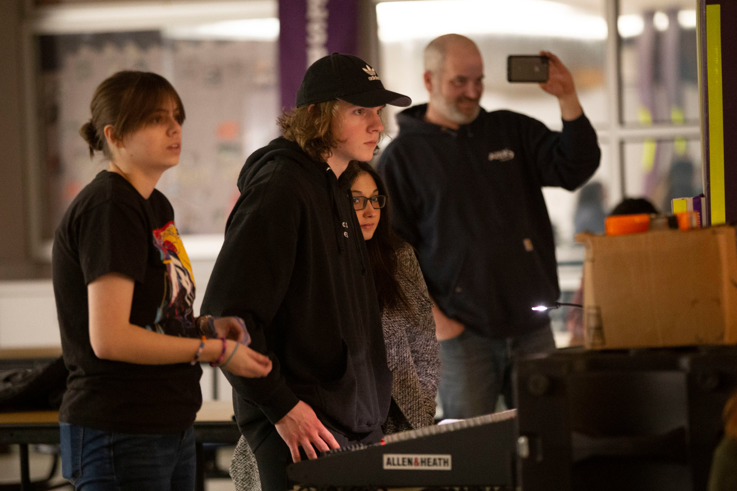 Lyla Birch (left) and Nick Perry work the sound board with Hannah de Jesus, a former grad and music cafe performer.