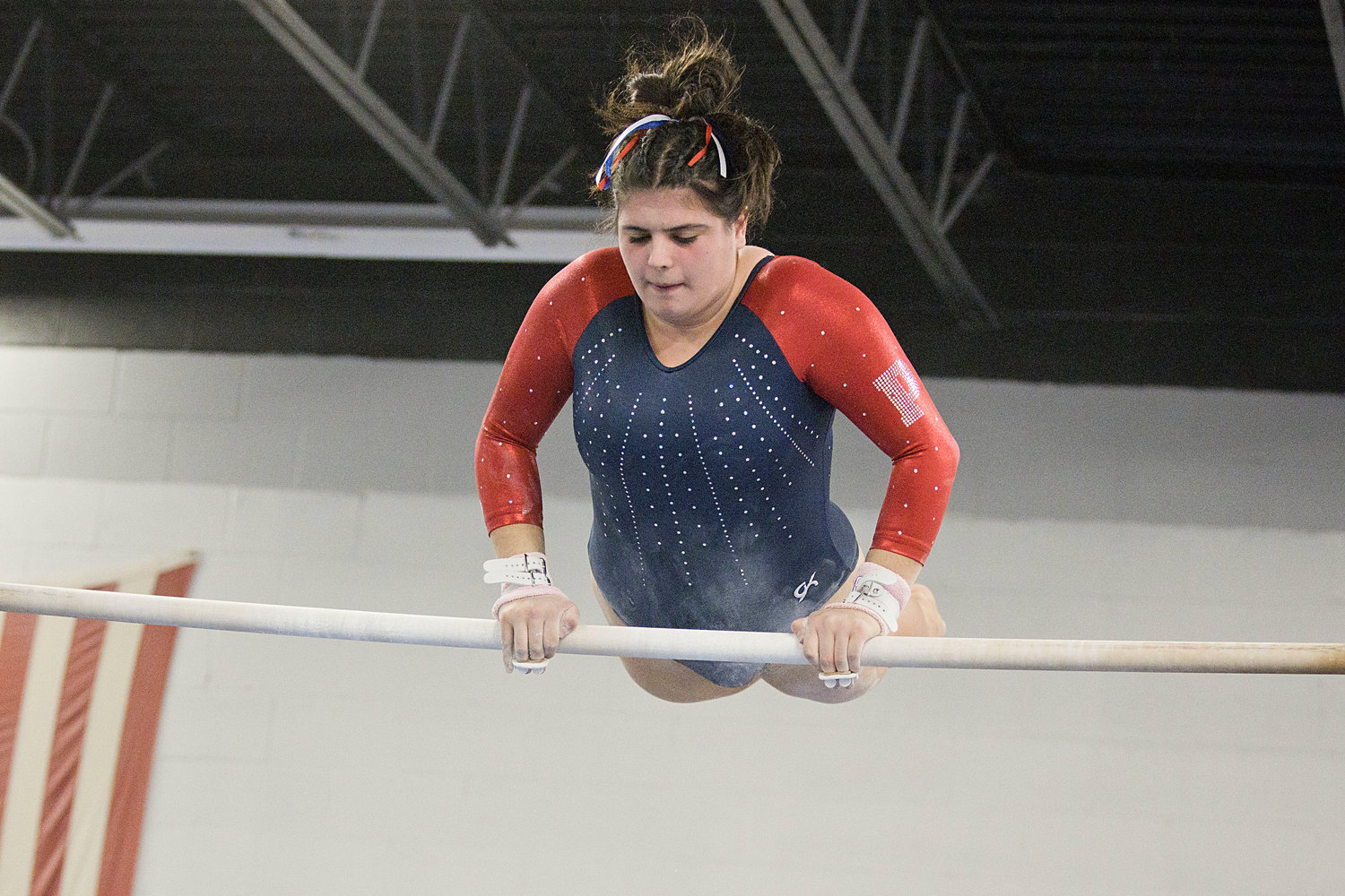 Kayla Oliveira lifts herself above the high bar while performing her routine on the uneven bars. She earned a 7.6 on the event.