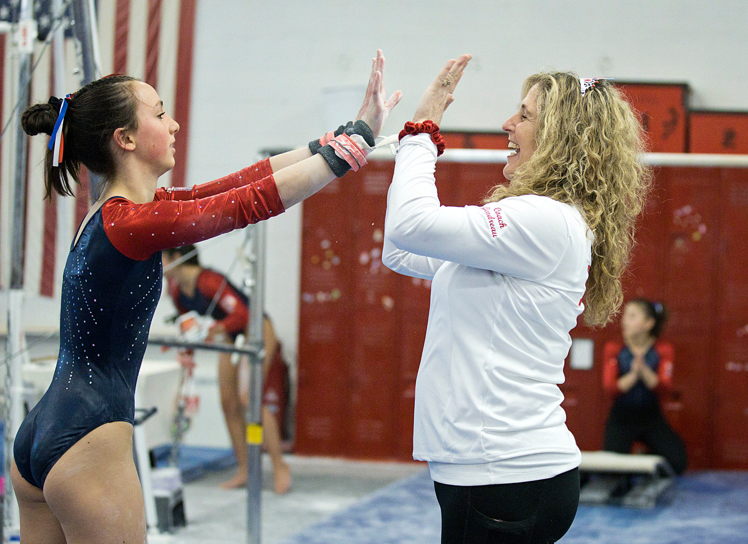 Rowan Snyder gets a high-five from head coach Melissa Gendreau after her performance on bars. Snyder scored an 8.5 in the event, and was the Patriots’ top scorer in the all-around, with 33.95 points.