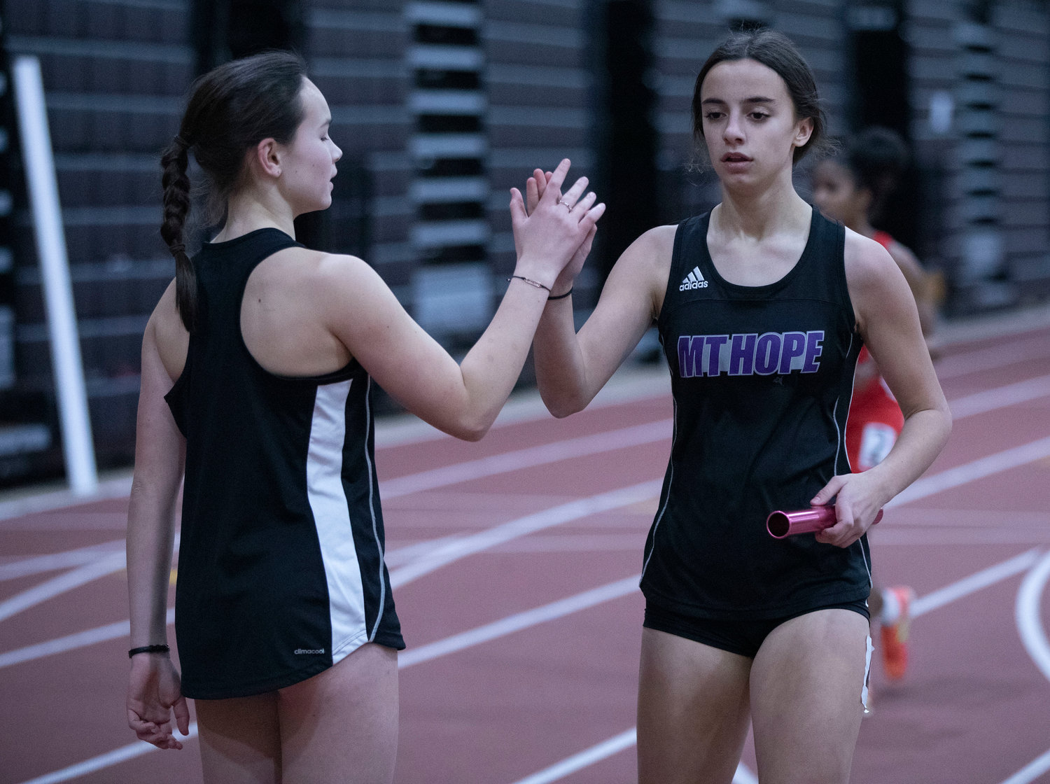 Ryan Coffey high fives teammate Thea Jackson after they placed second in their heat during the 4x400 relay.