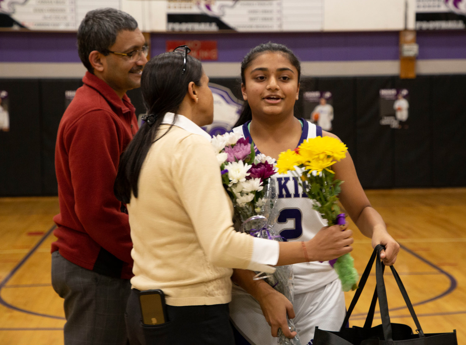 Shivani Mehta receives hugs and flowers from her parents.