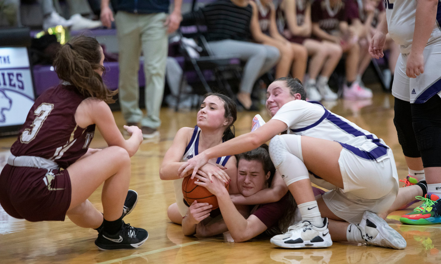 Tiverton guard Ellery Pacheco (left) tugs at the ball to help teammate Abbie Monkevicz (middle), while Huskies guard Maddy Butterworth and Reyn Ferris try to wrestle it away from her.