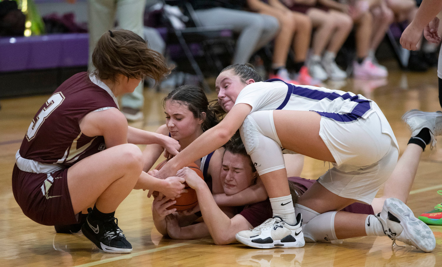 Tiverton guard Ellery Pacheco (left) tugs at the ball to help teammate Abbie Monkevicz (middle), while Huskies guard Maddy Butterworth and Reyn Ferris try to wrestle it away from her.