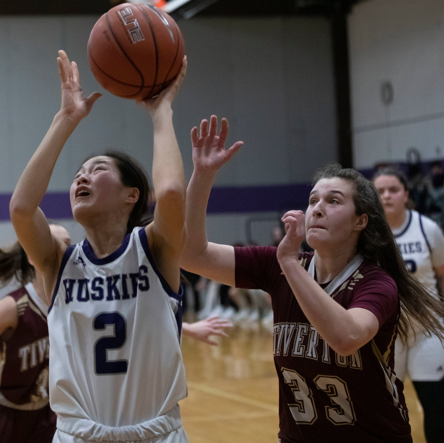 Huskies guard Elsa White drives in for a layup with Tigers forward Abbie Monkevicz defending.