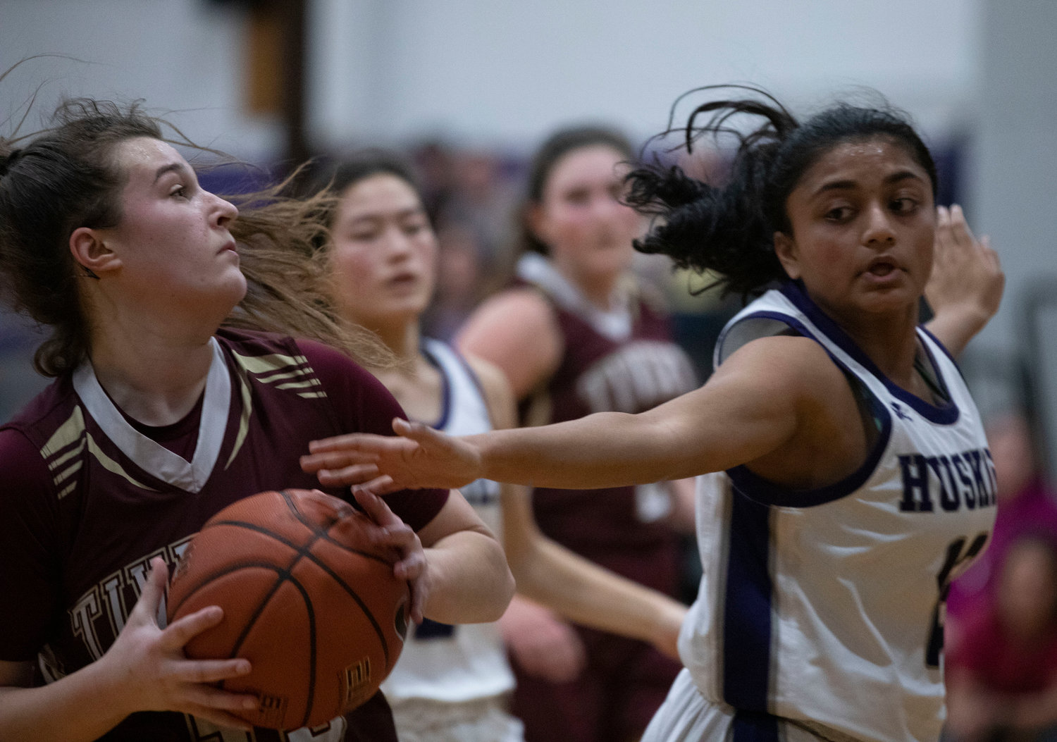 Abbie Monkevicz drives in for a layup with Shivani Mehta defending the Huskies hoop.