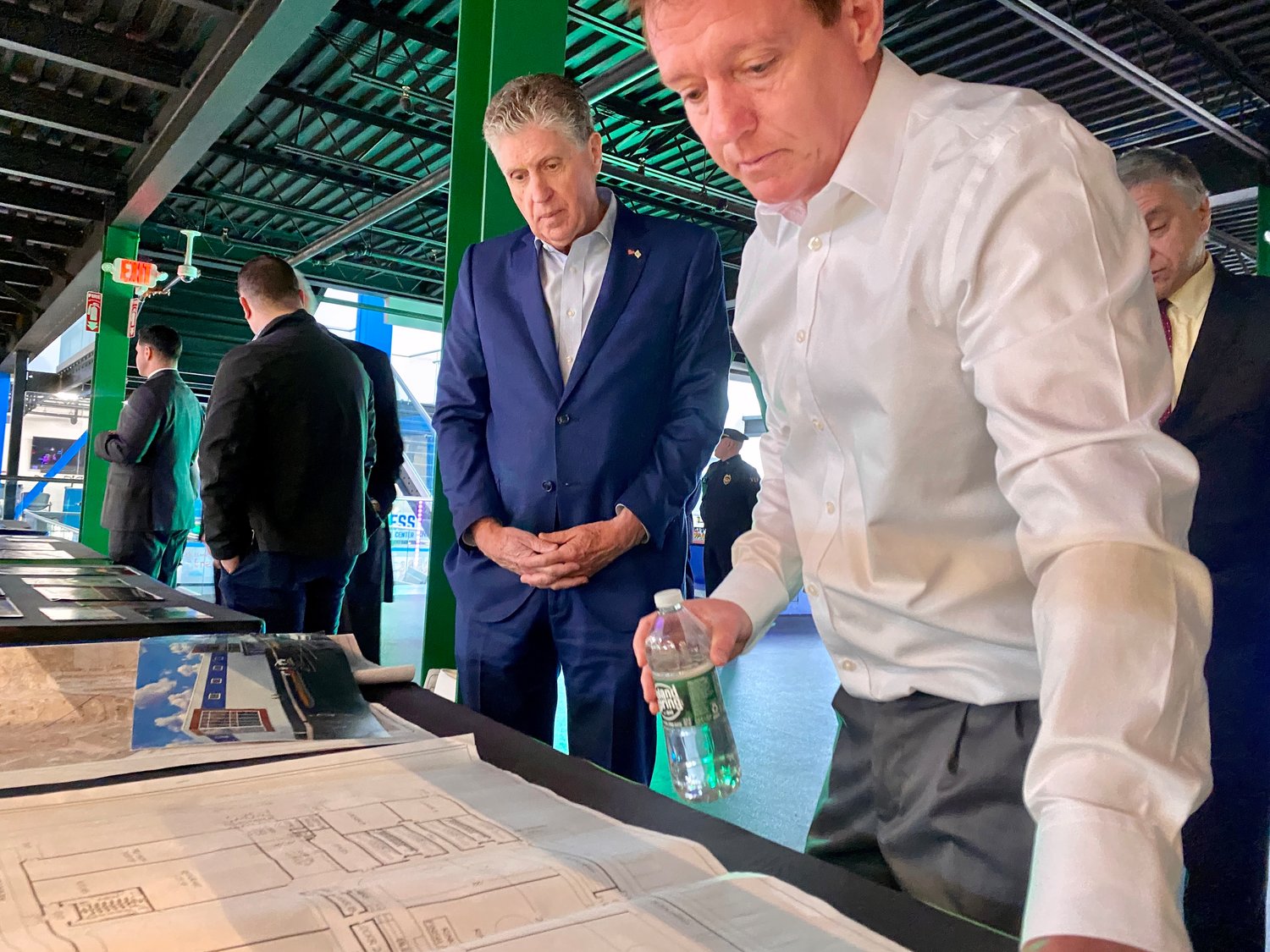 Longplex owner Jim Long (right) and Rhode Island Gov. Dan McKee go over original blueprints from the complex's construction, which began four years ago.