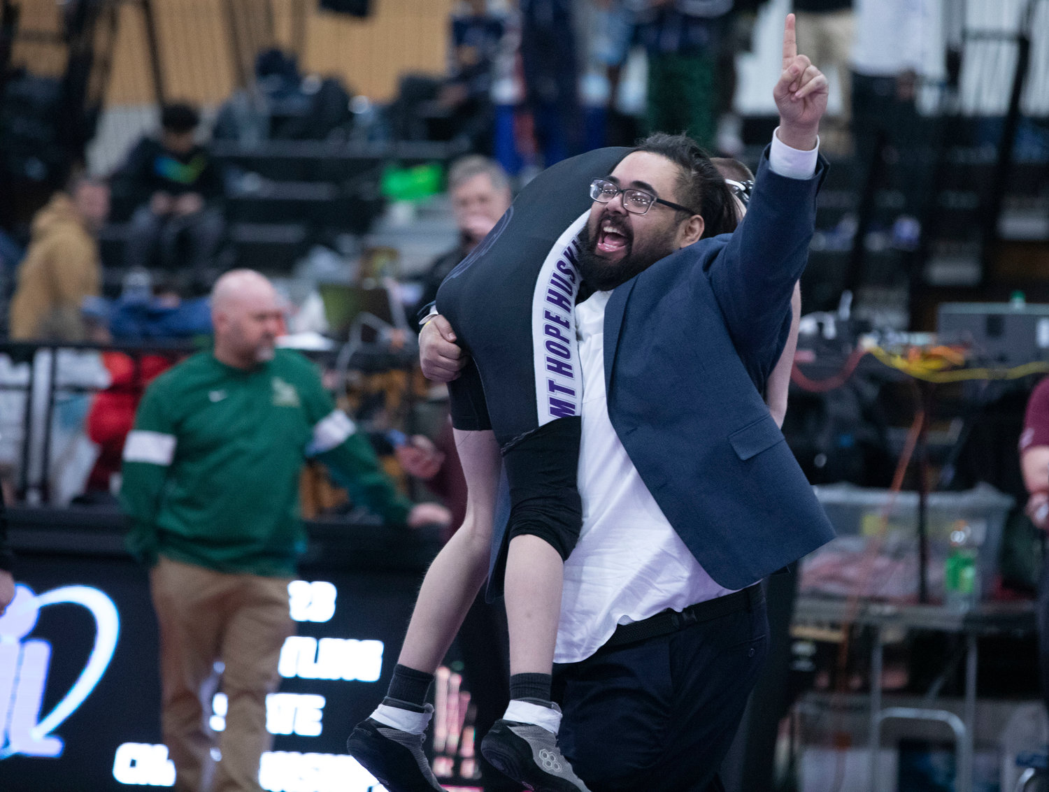 Head coach Ryan Fazzi hoists Andrew McCarthy over his shoulder and holds up a number one sign after McCarthy beat Stone Farnsworth of Coventry by a 3-1 decision to gain the 126-pound finals at the state tournament.