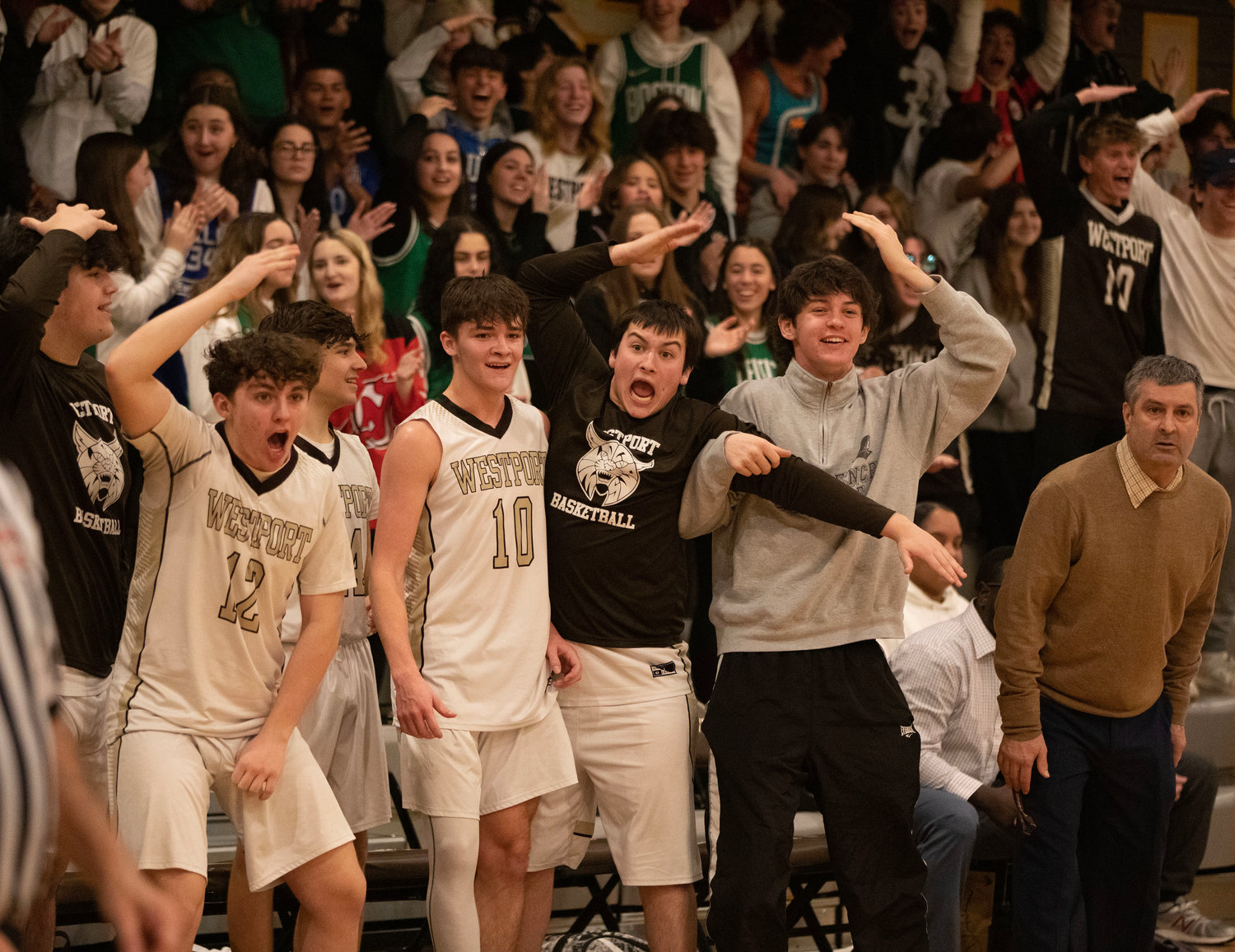 The Wildcats bench ignites after Hunter Brodeur sinks a basket to give Westport a 55-54 lead late in the fourth quarter.