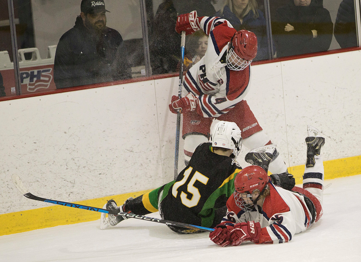 Andrew Alvanas digs the puck out from under teammate Shane Temple and a North Smithfield opponent.