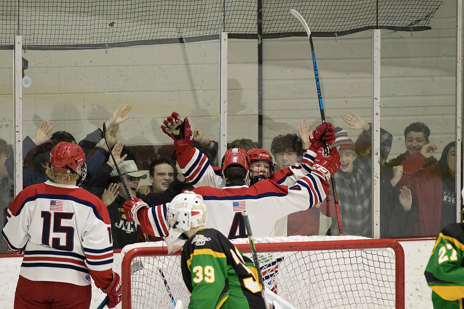 Fans pound on the glass while Andrew Alvanas and Joseph Levreault celebrate a first-period goal.