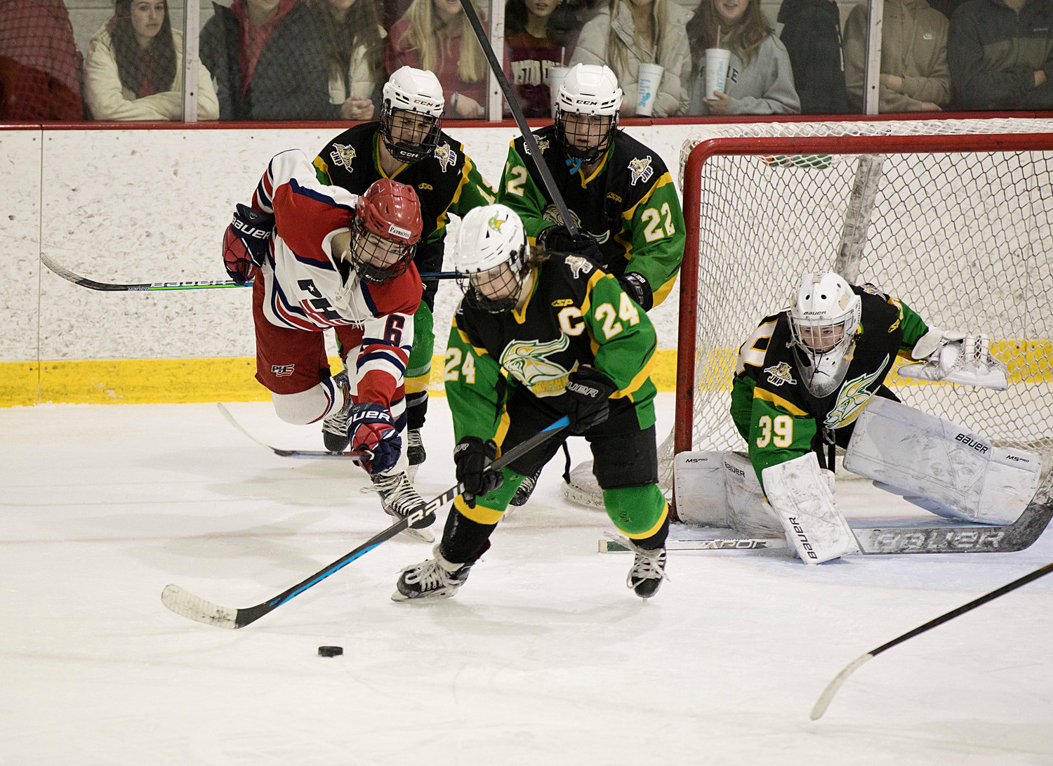 Henri Boneu reaches for the puck while surrounded by a trio of North Smithfield skaters.