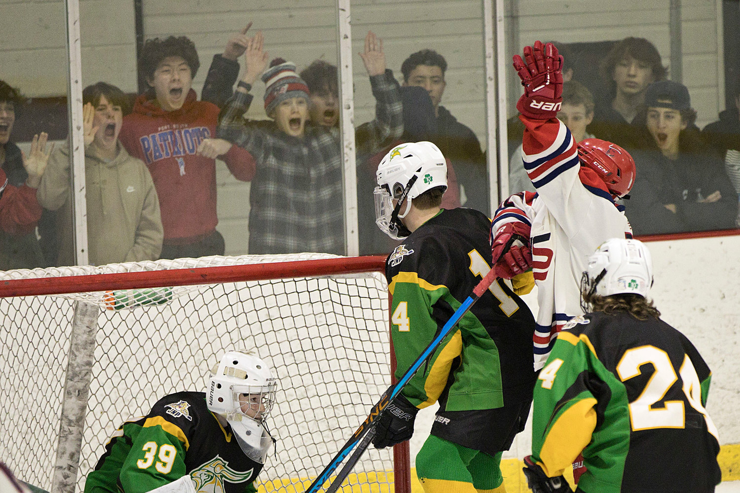 Portsmouth High’s Joseph Leveault (right) waves to fan after scoring a power-play goal in the first period of the opening game of the Division II quarterfinals against North Smithfield Friday at Portsmouth Abbey.