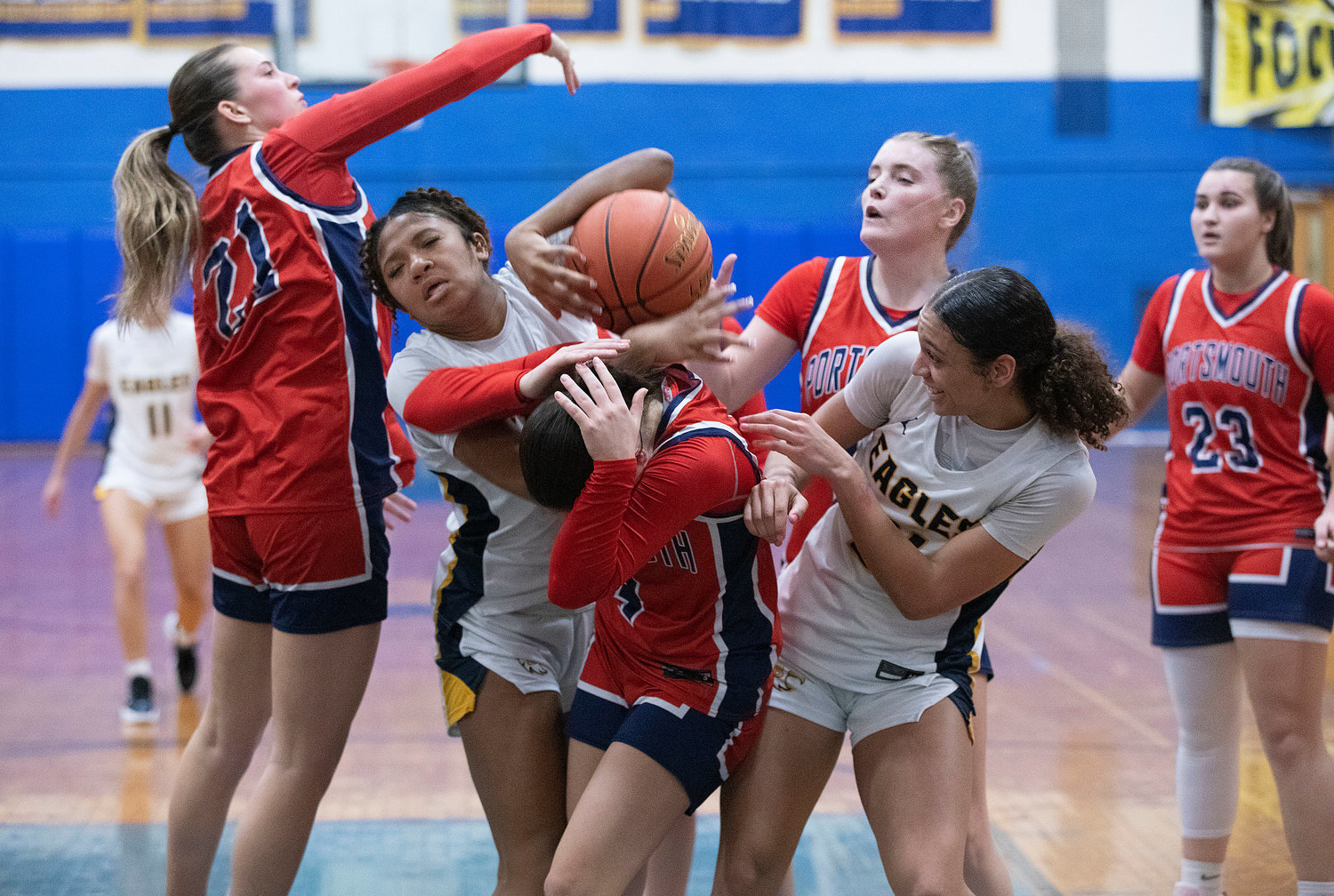 Portsmouth’s Ava Hackley (left) and teammates Olivia Durant and Maeve Tullson fight for a rebound with Barrington’s Lindsey Lamay (left) and Isys Dunphy during the opening game of the girls’ state basketball tournament on March 1.  Emily Maiato is at right. The Patriots upset the Eagles, 46-37.