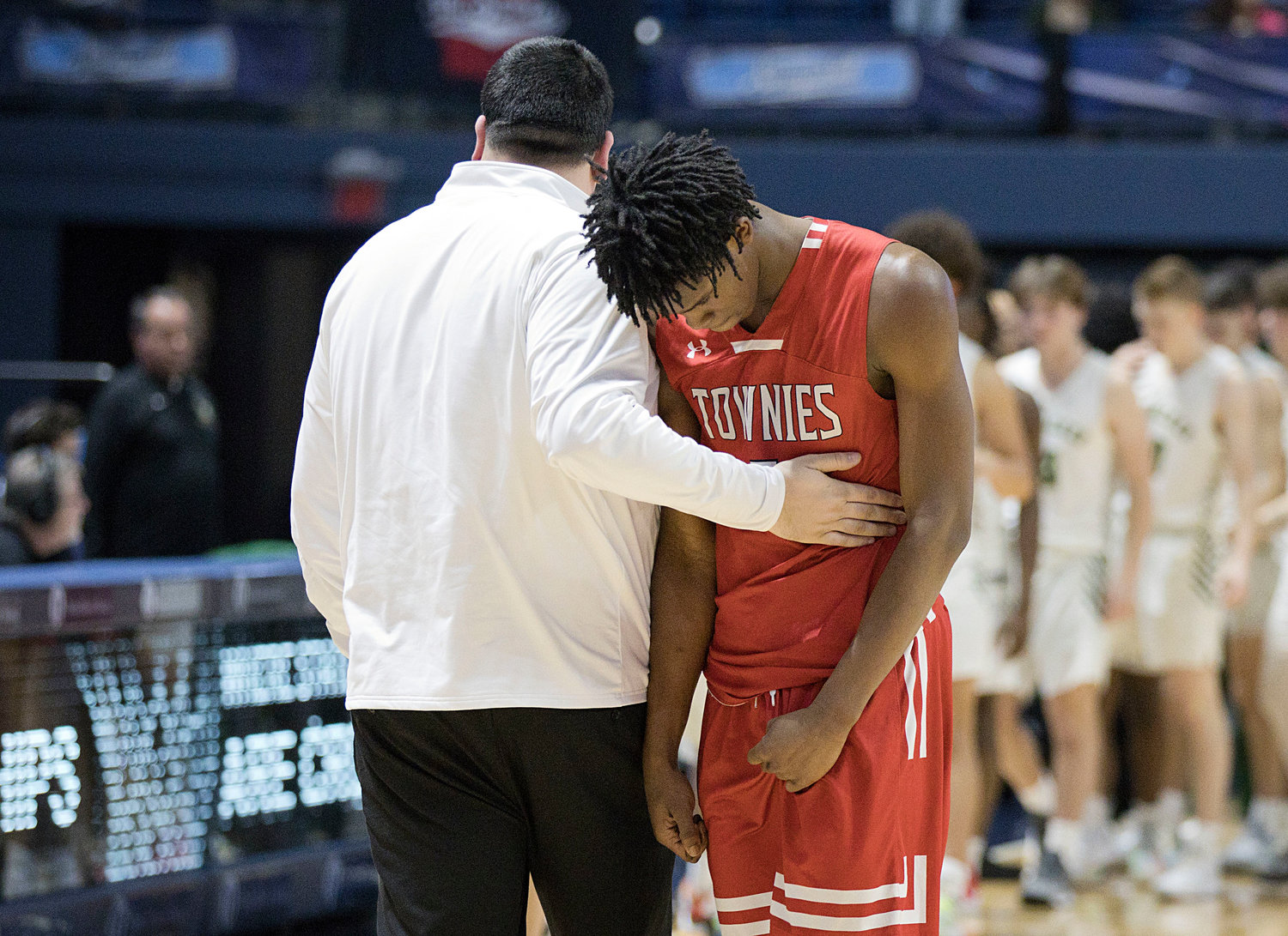 EPHS assistant coach Patrick Marchand consoles Kenaz Ochgwu at the end of the Townies' state semifinal loss to Hendricken Saturday, March 11.
