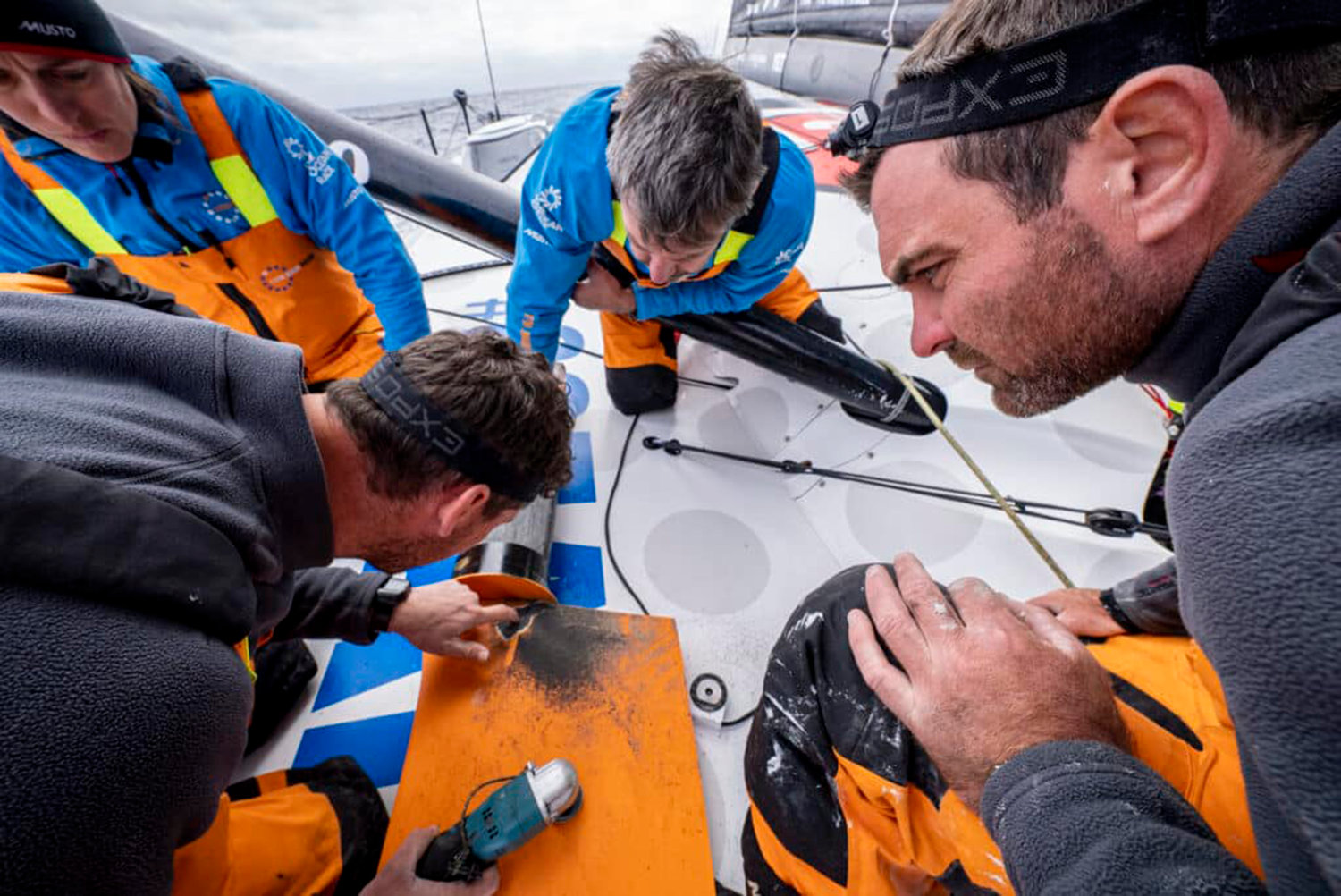 The Ocean Race 2022-23 - 07 March 2023, Leg 3 onboard 11th Hour Racing Team. The team watches as the outer layers of carbon are ground away, displaying the true extent of the cracks.