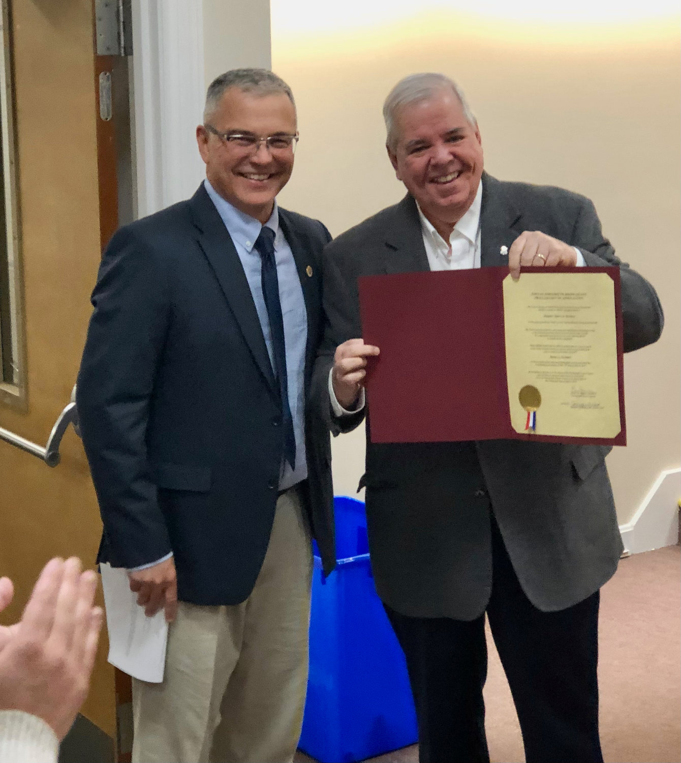 Former R.I. Sen. James Seveney shows off the proclamation that Town Council President Kevin Aguiar (left) had just presented to him during a brief ceremony at Monday night’s meeting. Seveney is also a former council president.