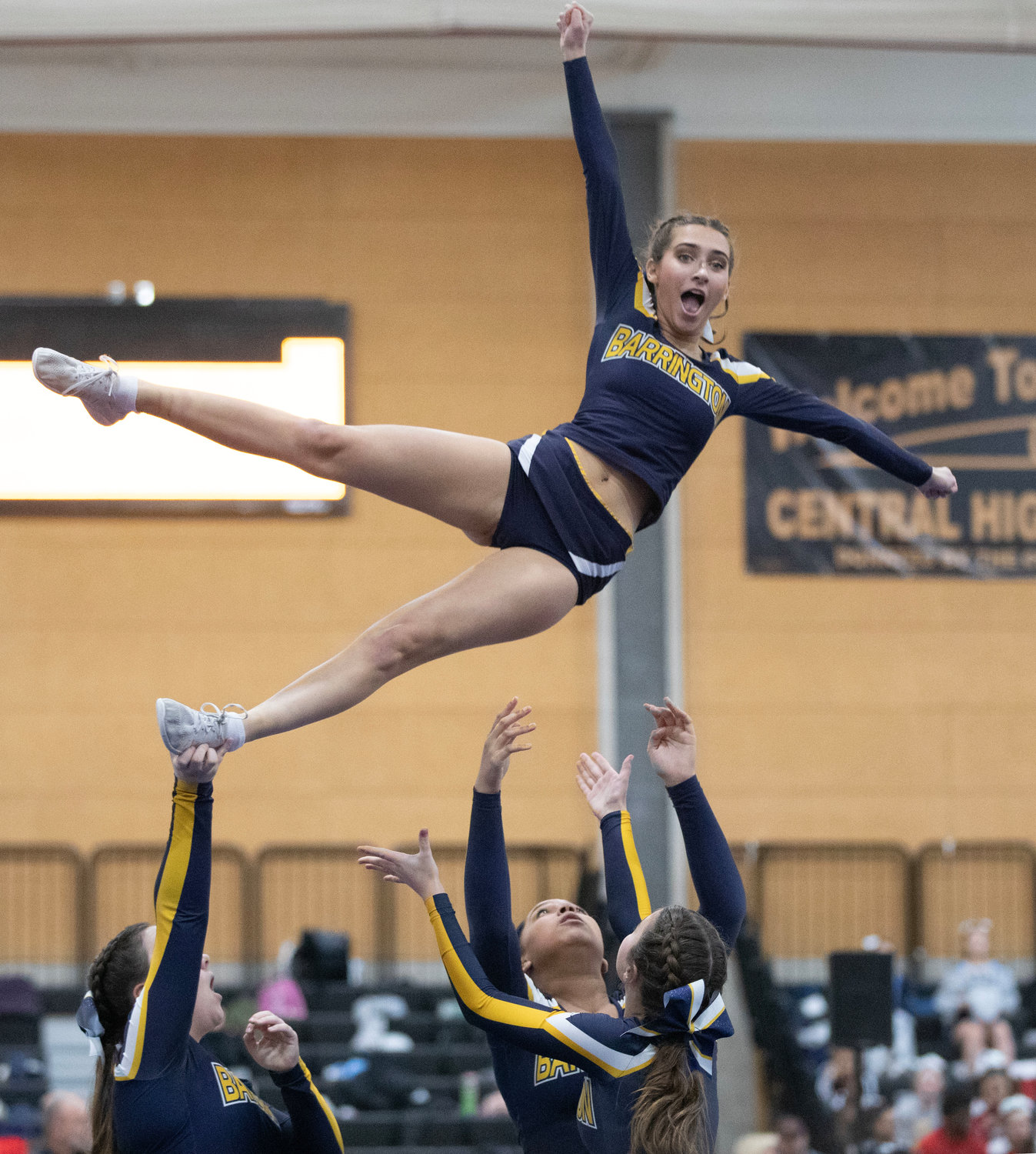Teammates throw Kaleigh Moran into the air during a stunt at the Rhode Island Interscholastic League Division II Cheer Competition.