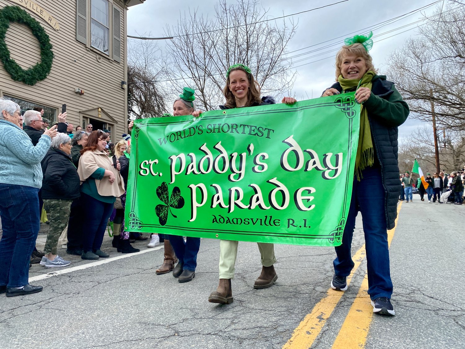Sue Manning, Stephanie Manning and Christine Carlile carry the parade banner at the start of the procession Saturday.