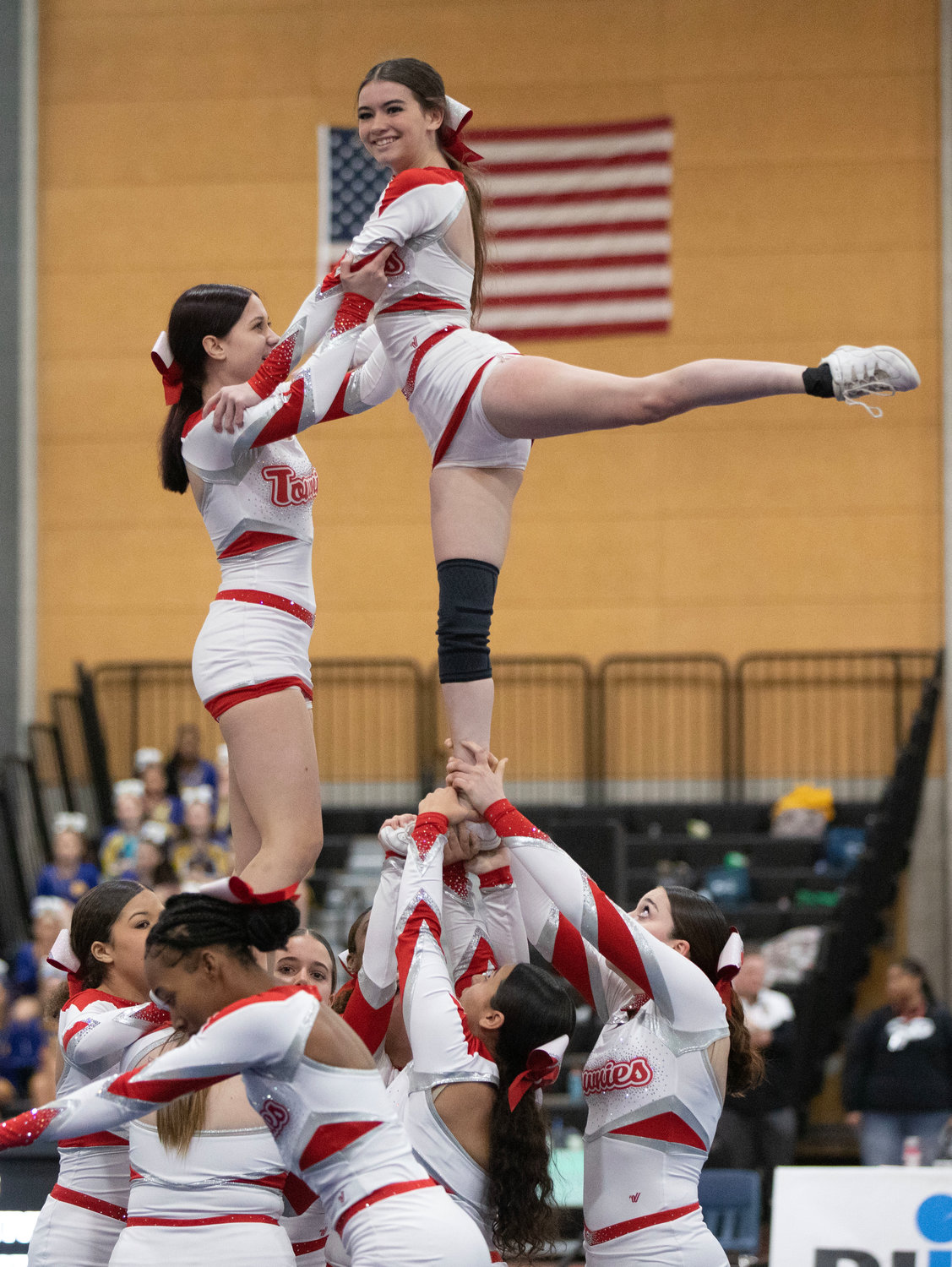 EPHS team members hoist flyers Kelci Richards-Cabral (left) and Mackenzie Pacheco into the air as they perform stunts during the State Competition Cheerleading Championships at the Providence Career and Technical Academy on Saturday, March 11.