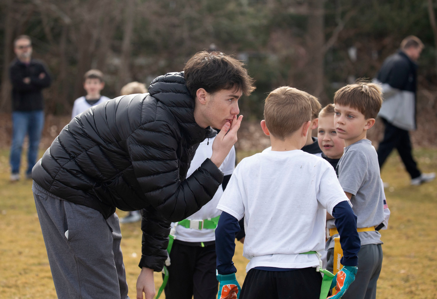 BHS student Jack Robinson (left) coaches a group of youngsters during the flag football tournament which was organized by Ryan O’Connell and Harrison Cooley as part of their Senior Projects.